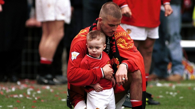 David Beckham inginocchiato con Brooklyn Beckham