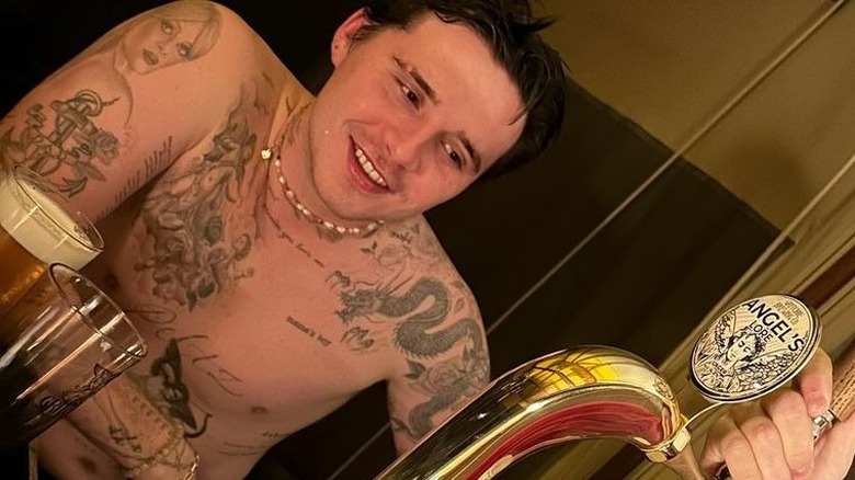 Brooklyn Beckham a torso nudo che sorride