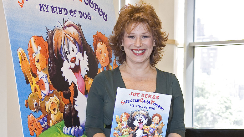 Joy Behar sorride mostrando il suo libro per bambini