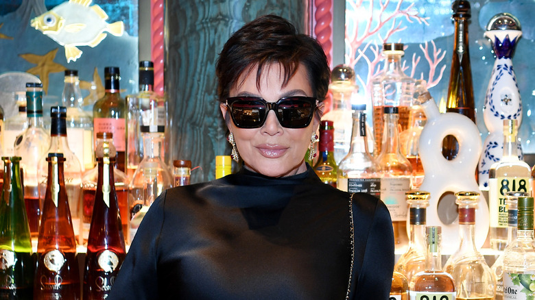 Kris Jenner sorride con gli occhiali da sole davanti al bar