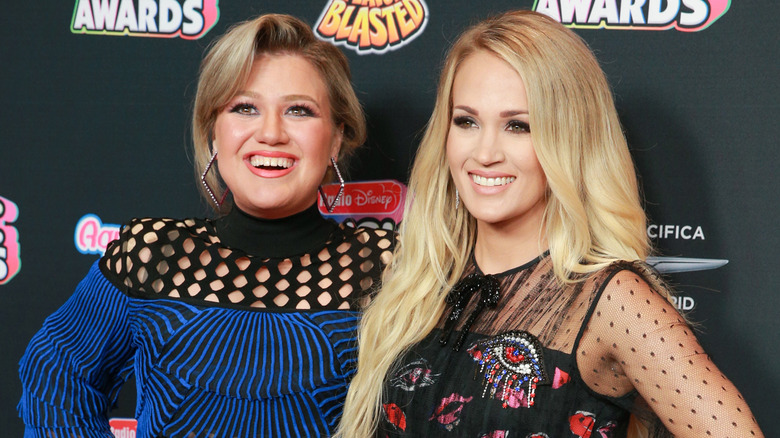 Kelly Clarkson e Carrie Underwood sorridono