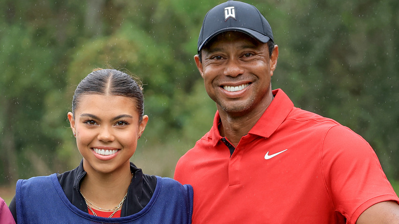 Sam Woods e Tiger Woods stanno insieme sorridendo