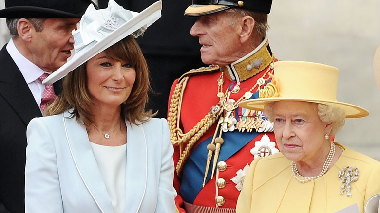 Carole Middleton sorridente, cappello giallo della regina Elisabetta II