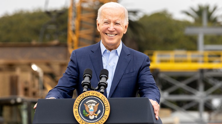 Joe Biden sorride dietro il podio