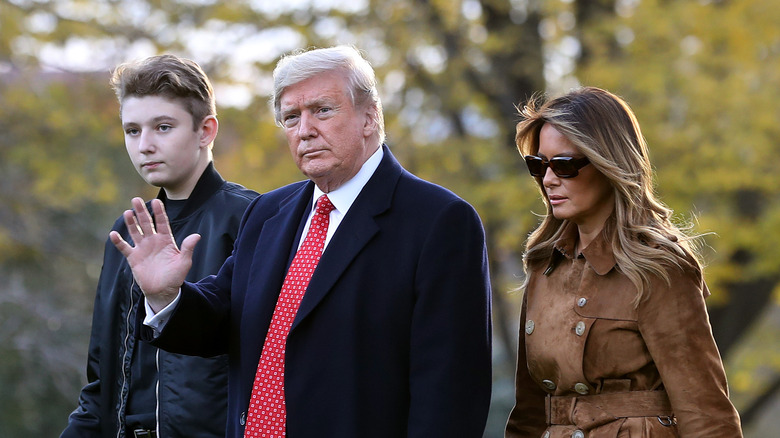 Barron, Donald e Melania Trump camminano