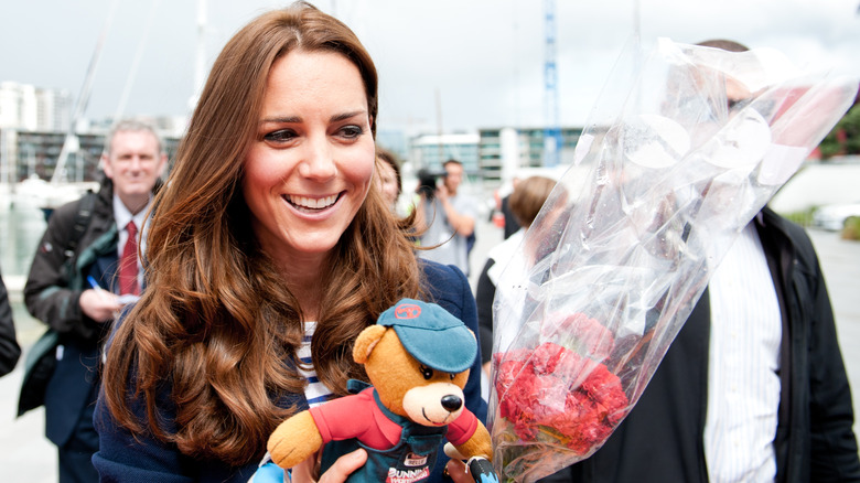 Kate Middleton tiene in braccio un orso e dei fiori