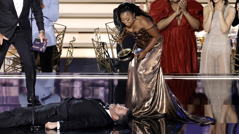 Jimmy Kimmel sdraiato sul palco con Quinta Brunson che lo guarda