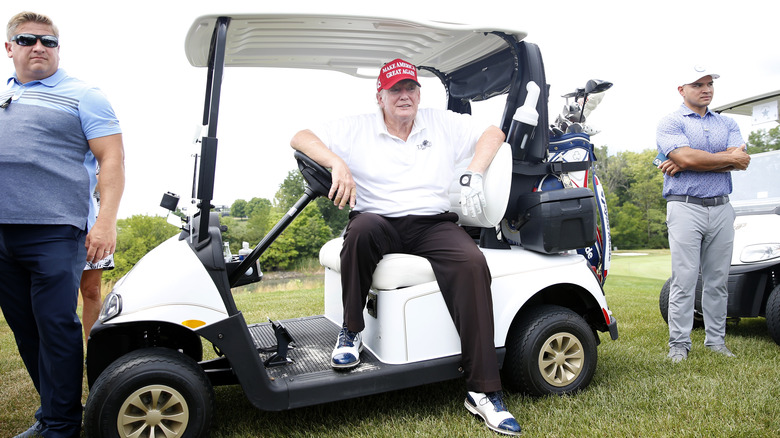 Donald Trump nel carrello da golf