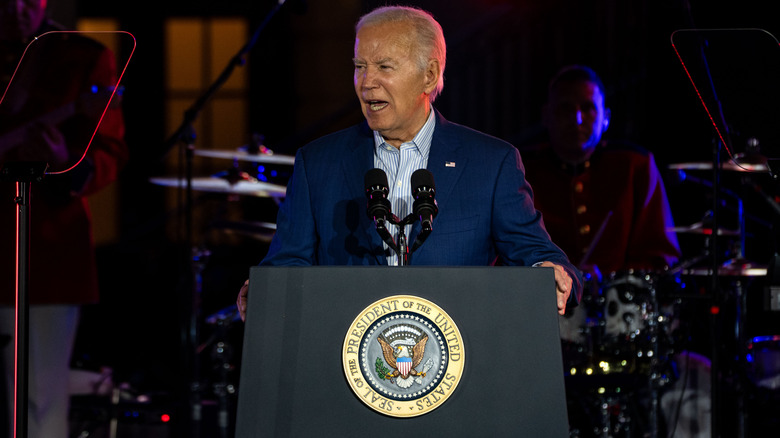 Joe Biden in abito blu parla sul podio