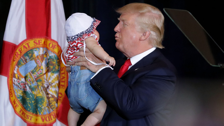 Donald Trump tiene in braccio il bambino