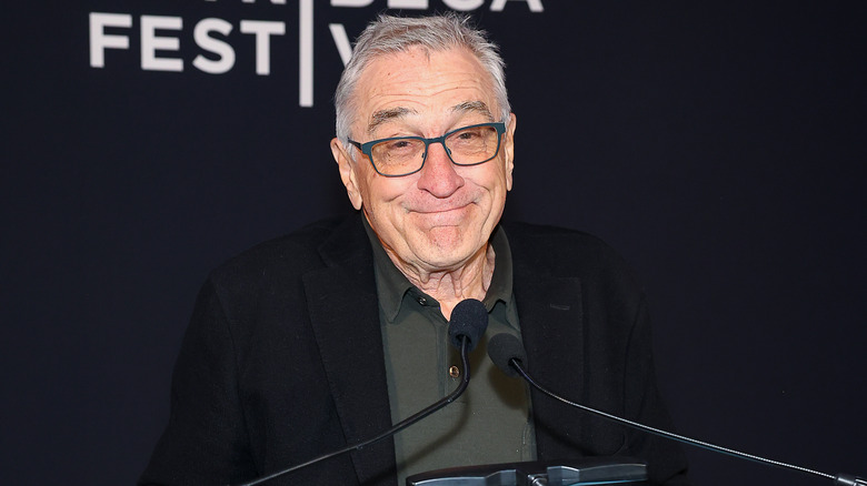 Robert De Niro sorride dietro il microfono