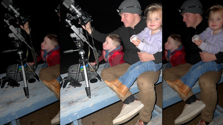 Garrison Brown e due bambini piccoli che guardano una grande telecamera