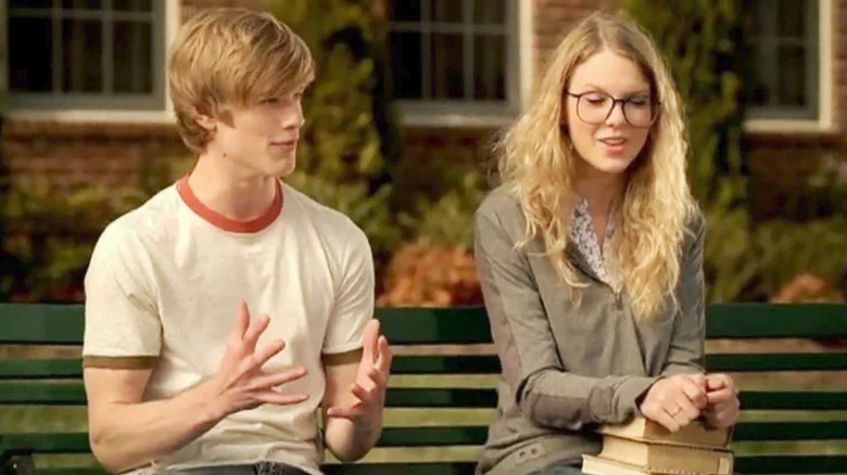 Lucas Till e Taylor Swift seduti sulla panchina