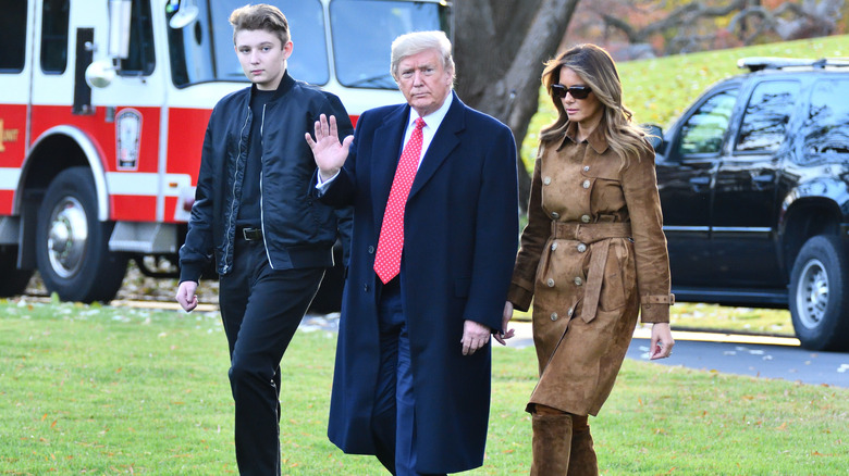 Barron, Donald e Melania Trump camminano