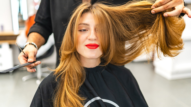 Donna che si fa tagliare i capelli a strati lunghi