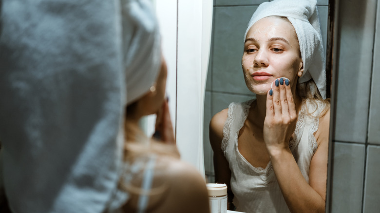 Donna che si lava la faccia in bagno