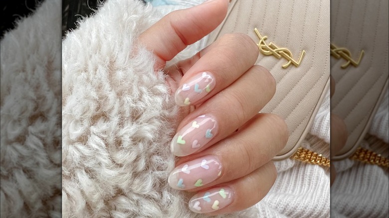 Manicure trasparente con cuori pastello