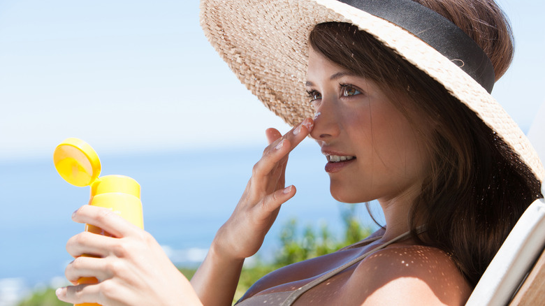 Una donna che applica la crema solare