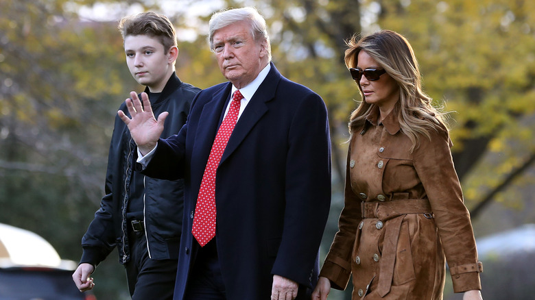 Barron, Donald e Melania Trump camminano