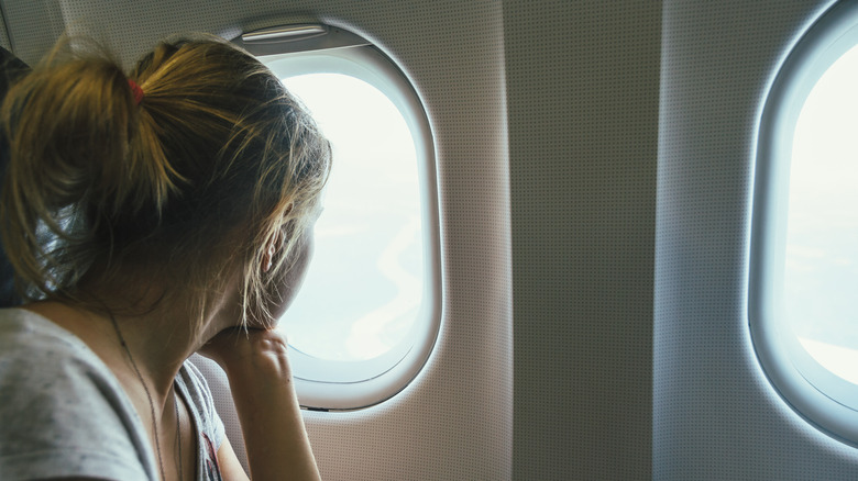 donna che guarda fuori dal finestrino dell'aereo 