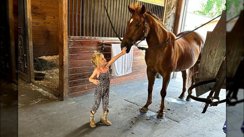 Carolina Trump accarezza il naso del cavallo