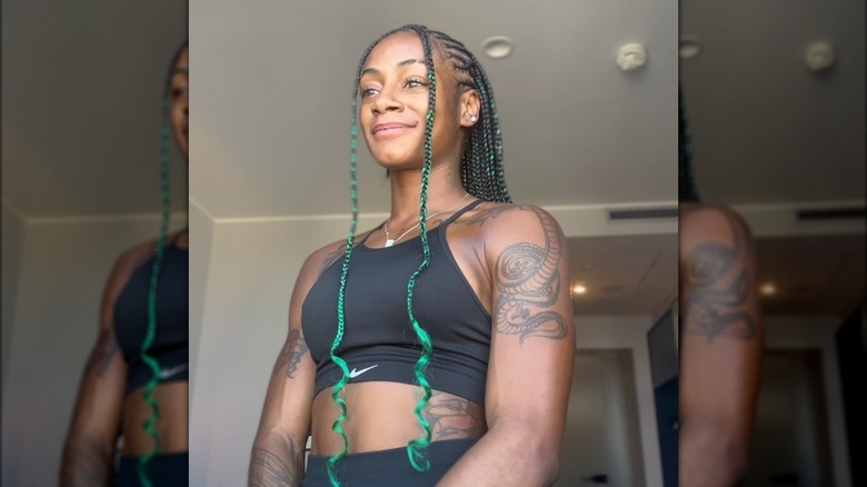 Sha'Carri Richardson sorridente con i capelli verdi