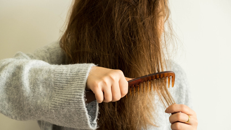 donna che pettina i capelli danneggiati 