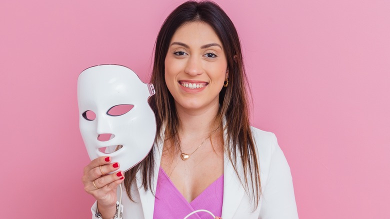 donna che tiene in mano una maschera per la terapia della luce