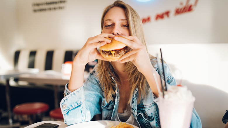 Una donna che mangia un hamburger