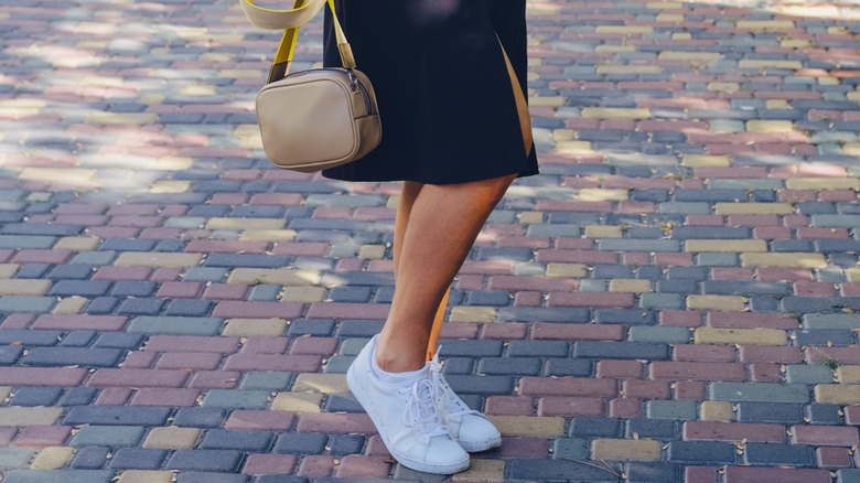 Donna che indossa scarpe da ginnastica bianche 