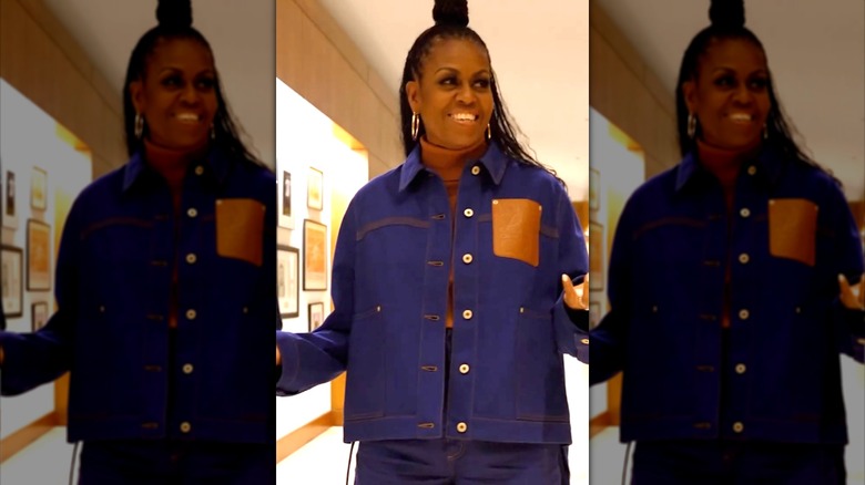 Michelle Obama sorridente in giacca di jeans