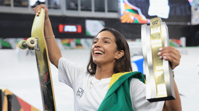 Rayssa Leal tiene in mano uno skateboard e un premio