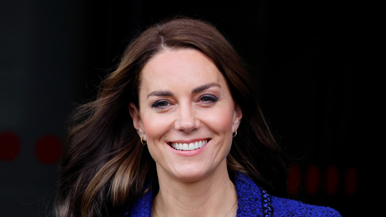 Kate Middleton sorride in abito blu