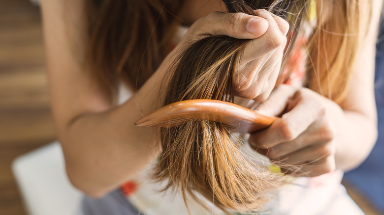 Donna che spazzola i capelli aggrovigliati