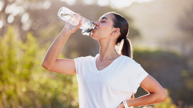 Donna che beve acqua all'aperto