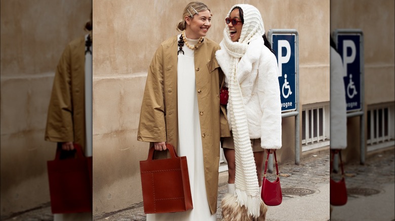 Donna in strada che tiene in mano una borsa rossa 