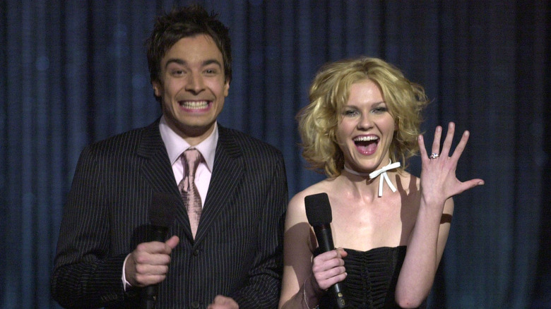 Jimmy Fallon e Kirsten Dunst sorridono con i microfoni