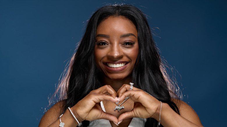 Simone Biles fa un cuore con la mano