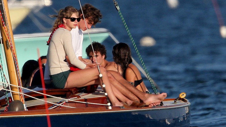 Taylor Swift e Conor Kennedy seduti su una barca