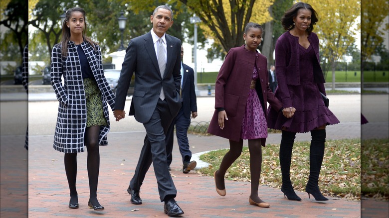 La famiglia Obama si tiene per mano, cammina