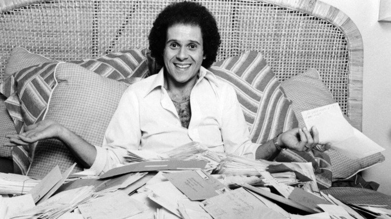 Richard Simmons tiene in mano delle lettere