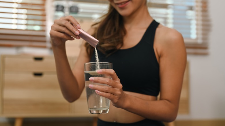 Donna che versa polvere nell'acqua