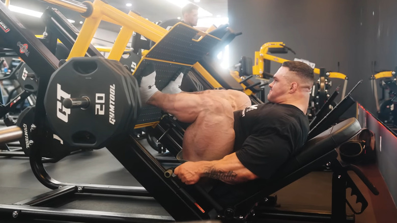 Nick Walker esegue la leg pressing con un peso pesante