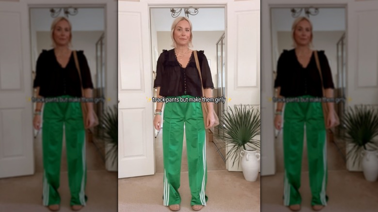 Donna che posa in pantaloni della tuta verde