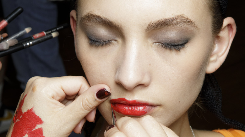 applicazione del rossetto rosso con pennello