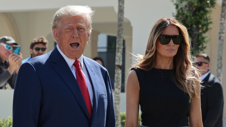 Donald Trump con la bocca aperta accanto a Melania Trump