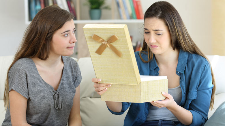 Donna a disagio e in colpa che scarta un regalo