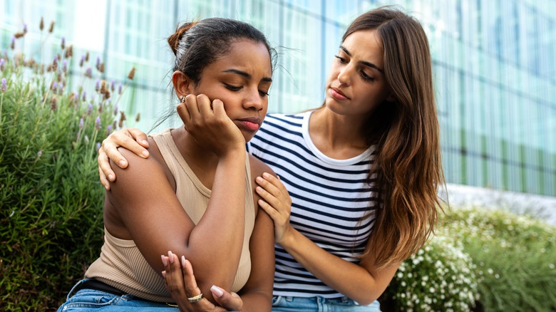 Donna che si scusa e conforta l'amica