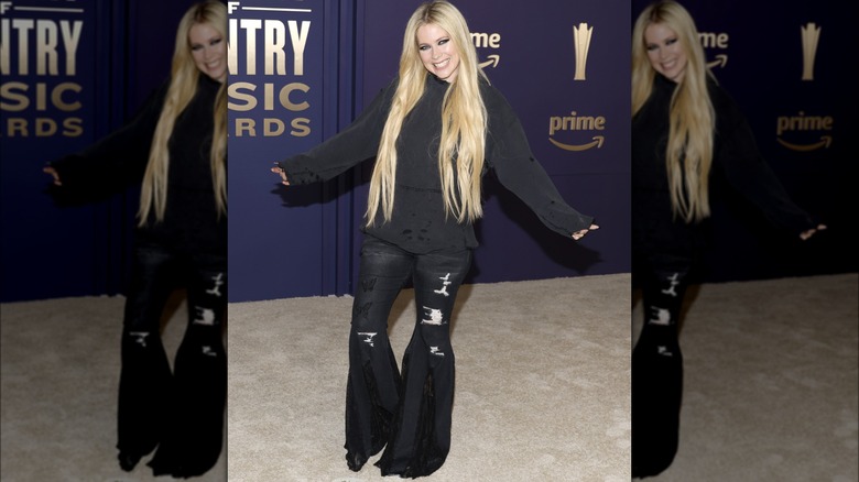 Felpa nera con cappuccio e pantaloni strappati di Avril Lavigne