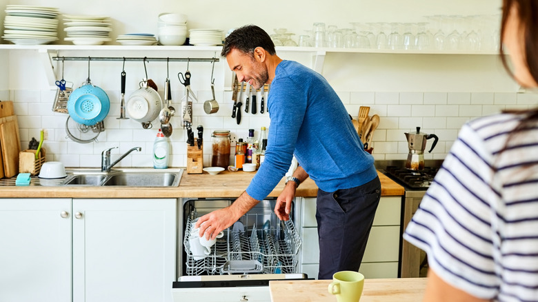 Partner maschile che aiuta con le faccende domestiche